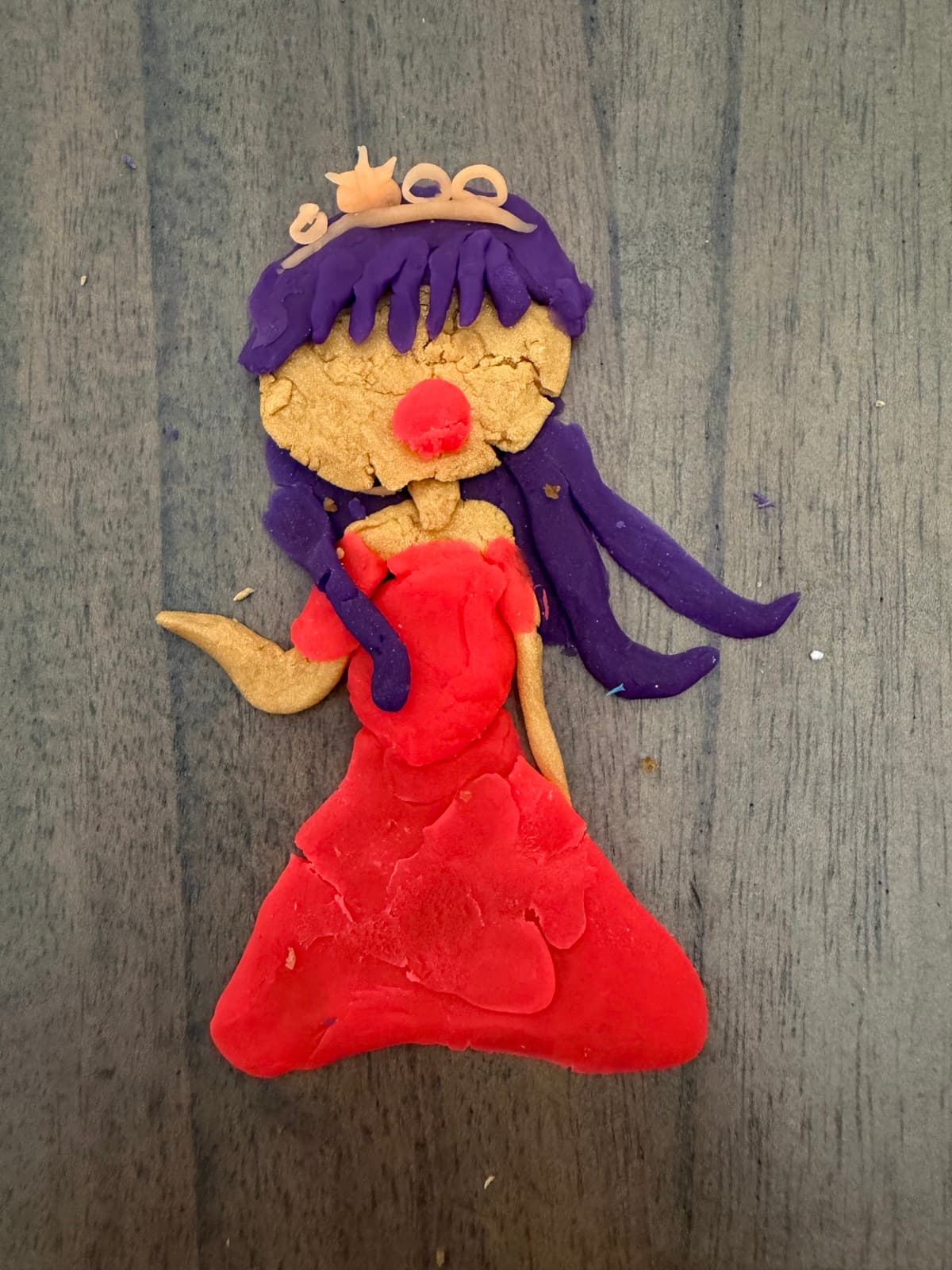 Clay figure of a princess in a red gown with a golden crown