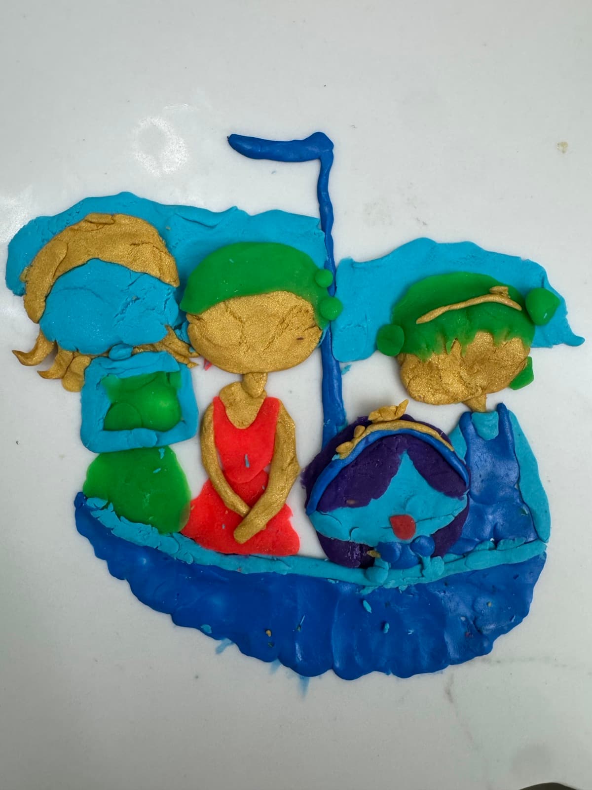 Clay artwork of three kids riding in a blue boat